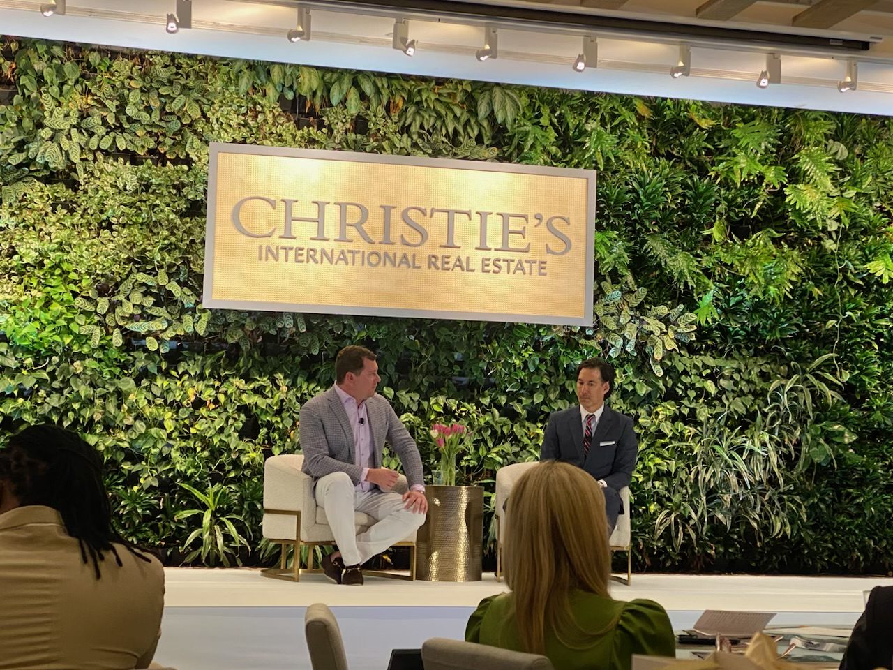 Damian Hall in conversation on stage beneath the Christie's International Real Estate sign at the brand's summit